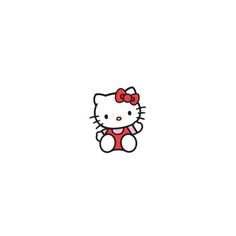 a hello kitty sitting on top of a white wall with a red bow around its neck