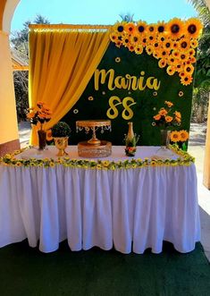 a table with sunflowers on it and a sign that says maniao's 8th