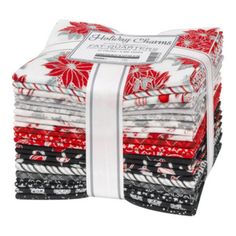 a stack of red, white and black christmas quilts