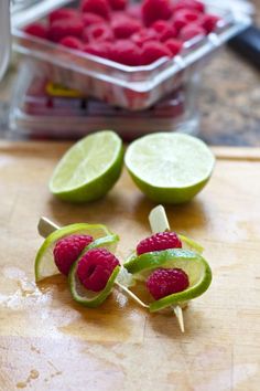 some raspberries and limes on a cutting board