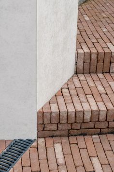 a cat sitting on the ground next to some steps and a building with a door