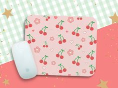 a pink cherry mouse pad with hearts and cherries on it next to a computer mouse