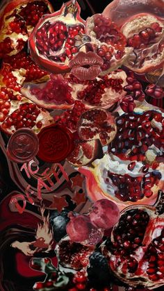 pomegranates and other fruits are arranged on a black surface