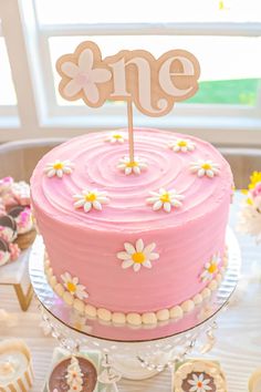 a pink cake sitting on top of a table