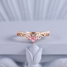 a pink diamond ring sitting on top of a white box