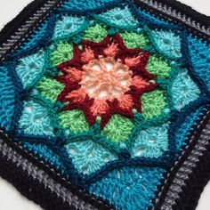 a crocheted square with a flower in the center