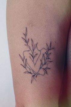 a woman's thigh with a heart and leaves tattoo on her left side ribcage