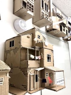 several cardboard houses are hanging on the wall