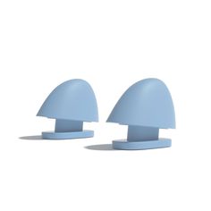 two light blue plastic objects sitting side by side on a white surface with shadows coming from them