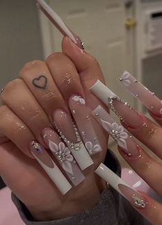 a person with long nails and white nail polishes on their hands, holding a pair of scissors