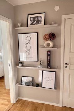 a white shelf filled with pictures and other items on top of a hard wood floor