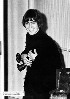 black and white photograph of a woman holding a hair dryer in front of a door