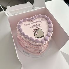 a pink and white birthday cake in a box