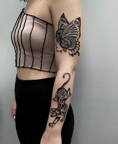 a woman with a tattoo on her arm and shoulder is posing in front of a wall