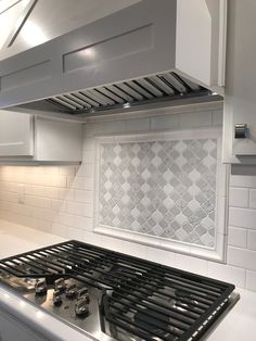 a stove top oven sitting inside of a kitchen next to a white tiled countertop