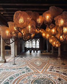 a large room with many lamps hanging from it's ceiling and floor tiles on the floor