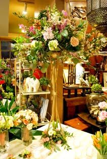 a room filled with lots of different types of flowers and vases on top of tables