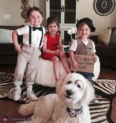 two children and a dog are sitting on the floor with a sign that says, my little hero club