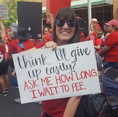 a woman holding a sign that says, think all give up causing ask me how long i wait to pee