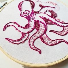 an embroidered octopus is shown in pink and white