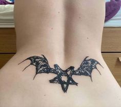 a woman's lower back tattoo with bats on it