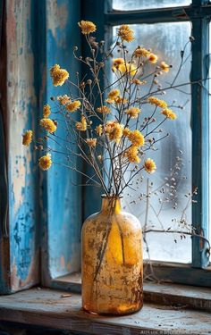 a vase filled with yellow flowers sitting on top of a window sill next to an open window