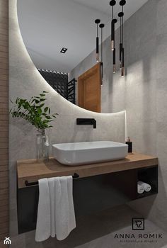 a bathroom with a sink, mirror and plants in vases on the counter top