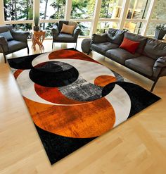 a living room area with couches, chairs and rugs on the hardwood floor