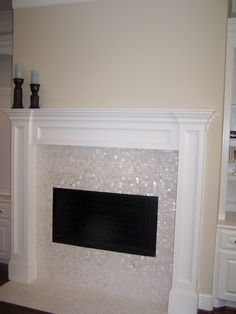 a white fireplace with a black mantle in the middle