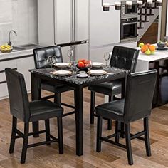 a kitchen table with four chairs and plates on the table in front of an oven