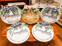 three grandma's and grandkids wooden signs with bows on them sitting on a table