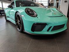 a blue porsche sports car in a showroom