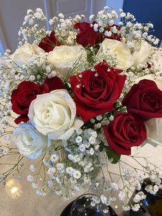 a vase filled with white and red roses