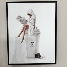 a woman sitting on top of a trash can next to a cell phone and newspaper