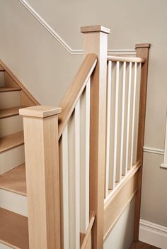 a wooden staircase with white railing and wood handrail