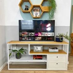 a television is sitting on top of a white entertainment center with shelving and shelves