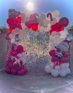 two giant balloons are in the shape of santa clause and candy canes