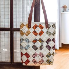 a quilted bag hanging from the side of a window