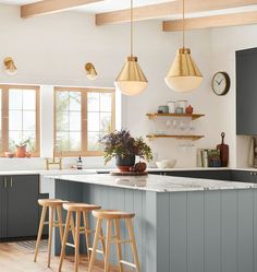 a kitchen with two stools next to an island