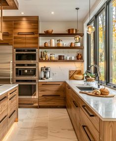 a kitchen filled with lots of wooden cabinets and counter top space next to a window