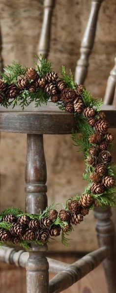 a chair with pine cones and greenery on it