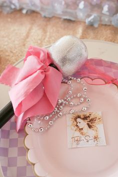 a pink rose on a plate with a beaded ball and some other items sitting on it