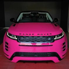 a bright pink range rover is parked in a parking garage with its hood up and lights on