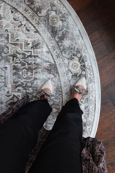 a person standing on top of a rug with their feet propped against the area rug