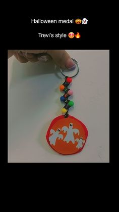 someone is holding a halloween themed keychain with ghostes and candy on it