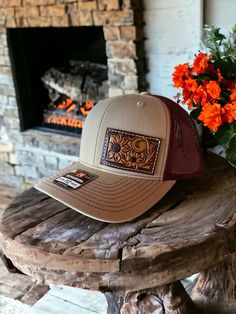 Mid trucker hat with one of a hand tooled leather patch. Patch features floral carving and sunflowers. Hat is SnapBack adjustable and is red and khaki tan in color. PLEASE READ: This item is for pre-ordering, and is made to order! Once purchased, this item will take approximately two weeks to re-create. Item will be a close replica, but each one will have slight variances in color, carving, etc. as I am not perfect, and leather is not perfect either! Outdoor Brown Hats With Leather Backing, Outdoor Brown Hat With Leather Backing, Brown Hats With Leather Backing For Outdoor, Brown Hat With Leather Backing For Outdoor, Adjustable Leather Snapback Hat In Brown, Brown Leather Snapback Hat, Adjustable Leather Brown Snapback Hat, Adjustable Brown Leather Snapback Hat, Brown Western Style Baseball Cap For Outdoor