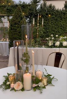 a table with candles and flowers on it in front of some tables set up for an event