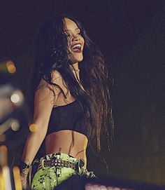 a woman in black top and green skirt on stage