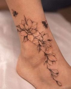 a woman's foot with flowers and bees on it