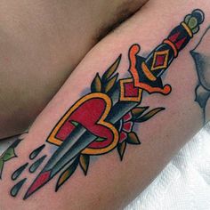 a tattoo on the arm of a person with a knife and dagger in front of them